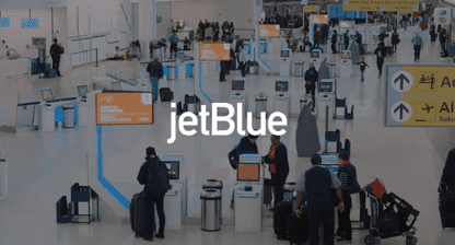 Jetblue logo overlaying image of an airport terminal with people checking in at kiosks