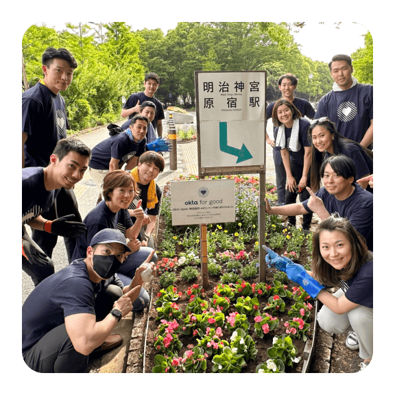 Image of Okta colleagues posing near garden