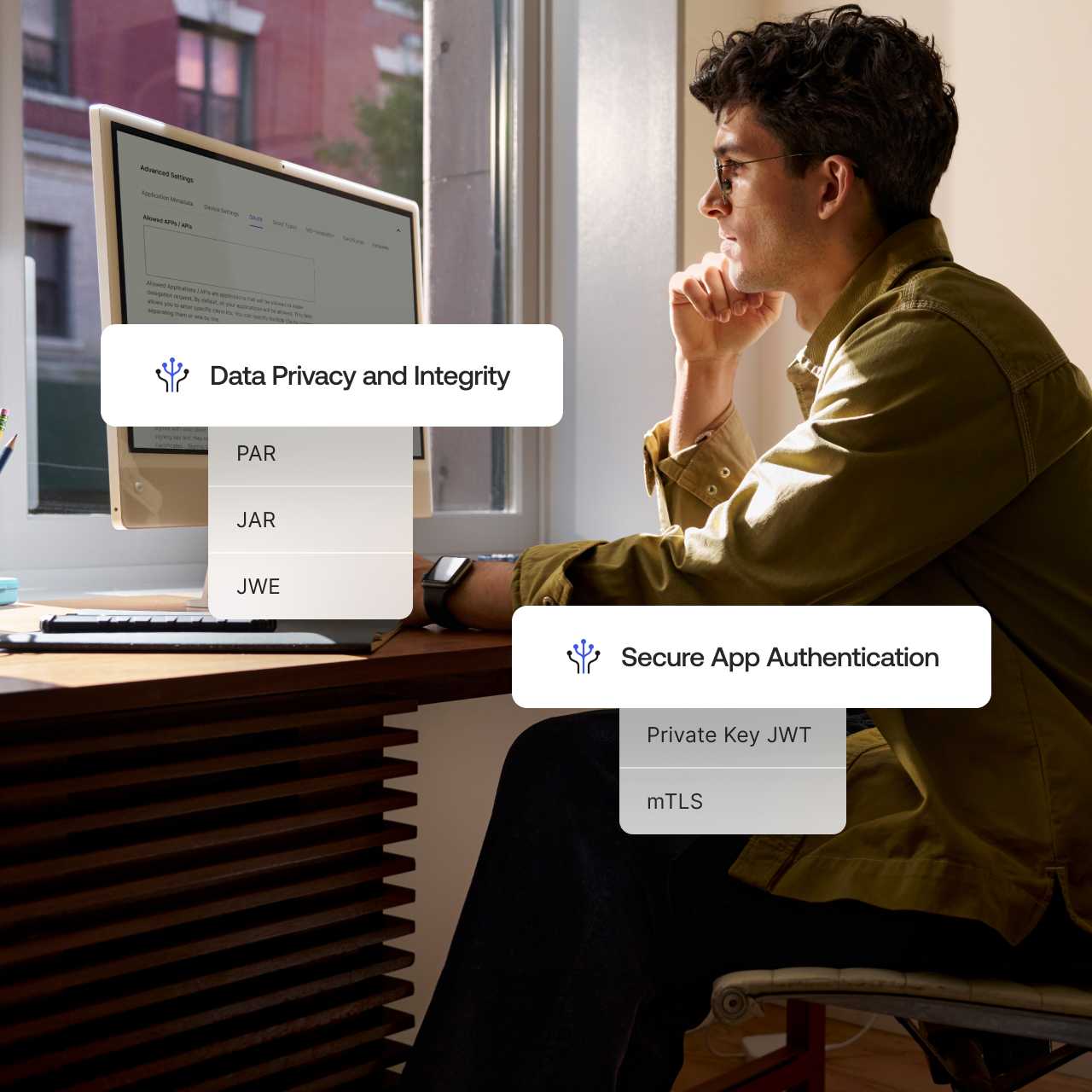The words Data Privacy and Integrity and Secure App Authentication overlaying an image of a man working on desktop computer.