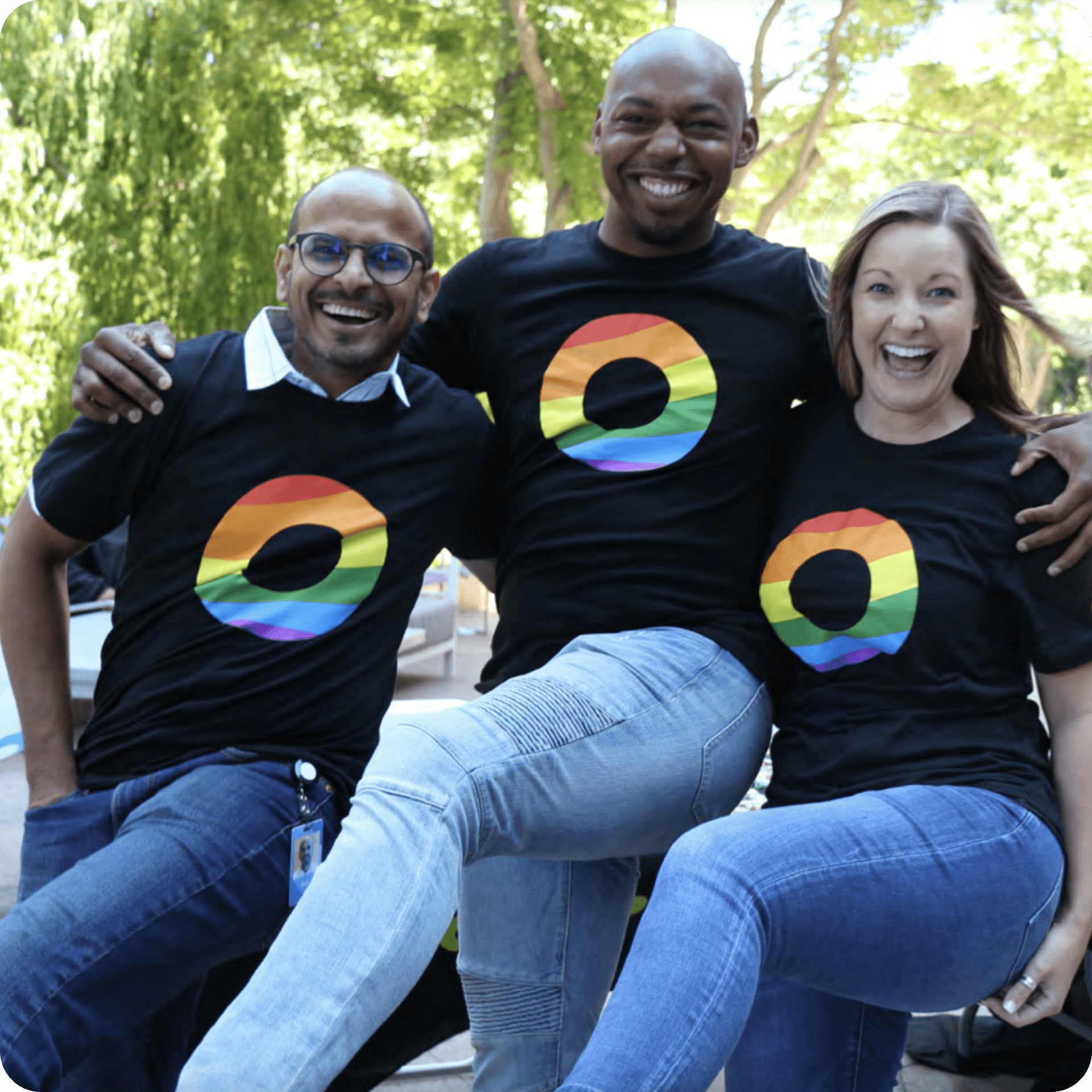 Three Okta employees wearing Okta Pride shirts