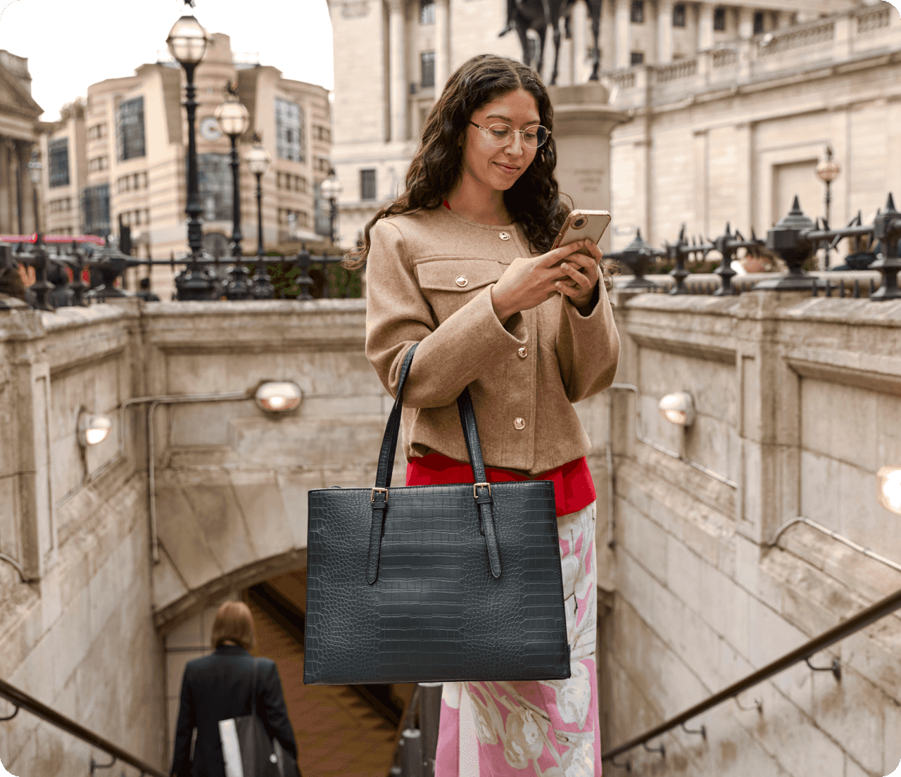 Professionally dressed woman uses mobile phone in front of Parliament buildings