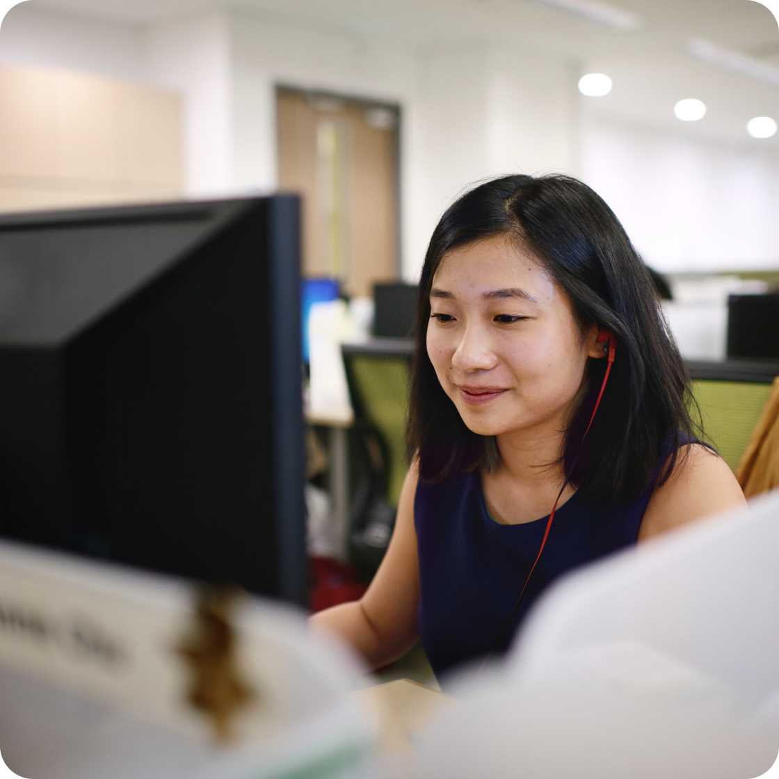 Woman sitting at desk while using computer.