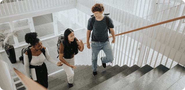 Three teenagers walking up school stairs