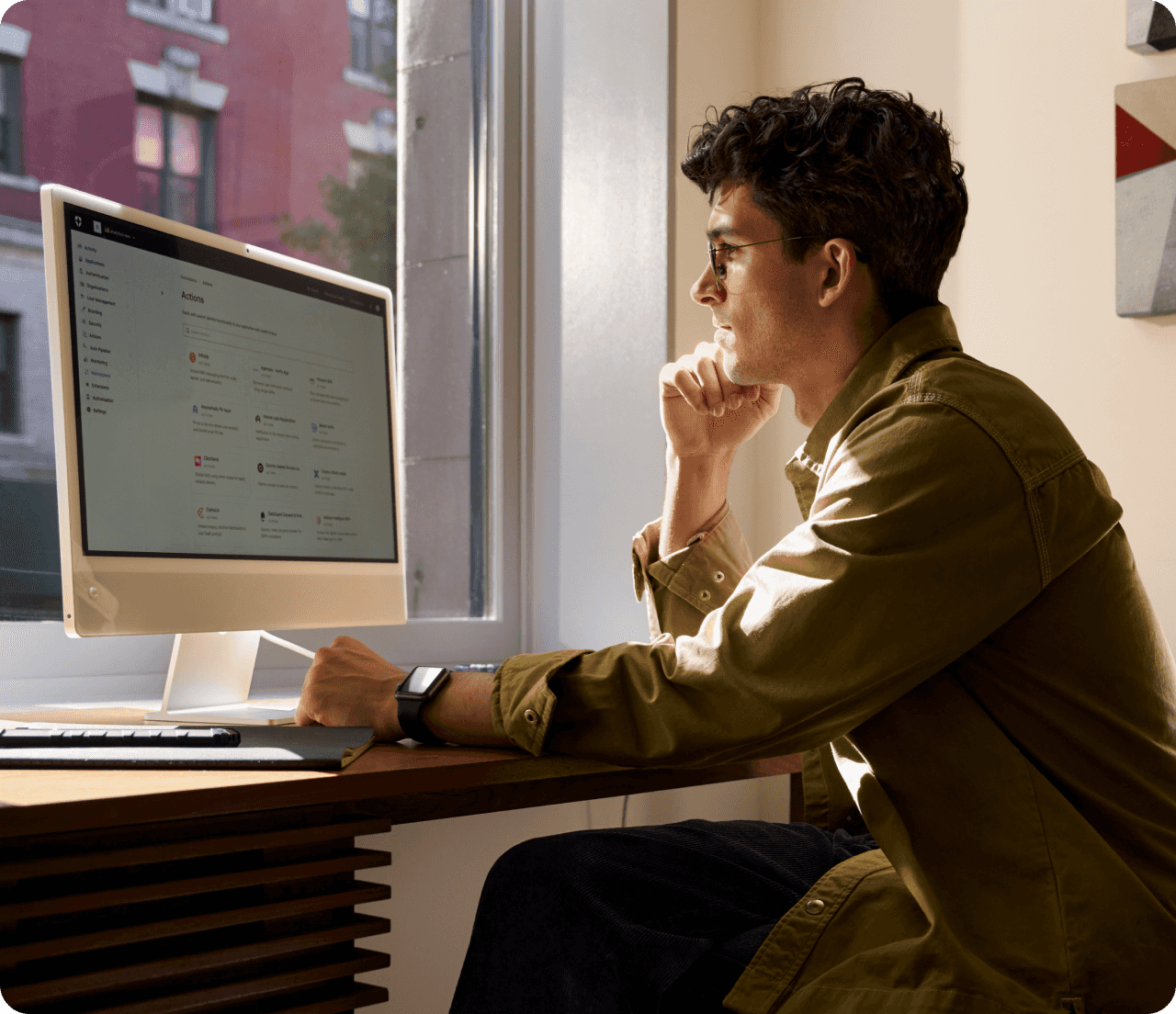 Man working on his computer in front of a window.