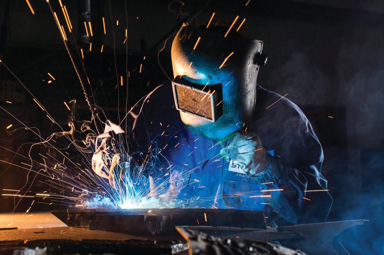 person in welder's protective clothing at work