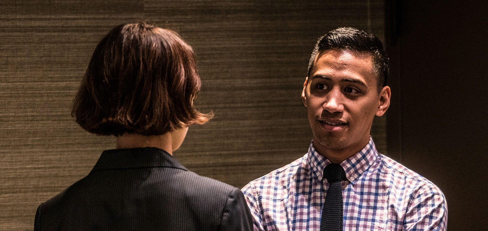 People facing each other in a professional setting with dramatic lighting