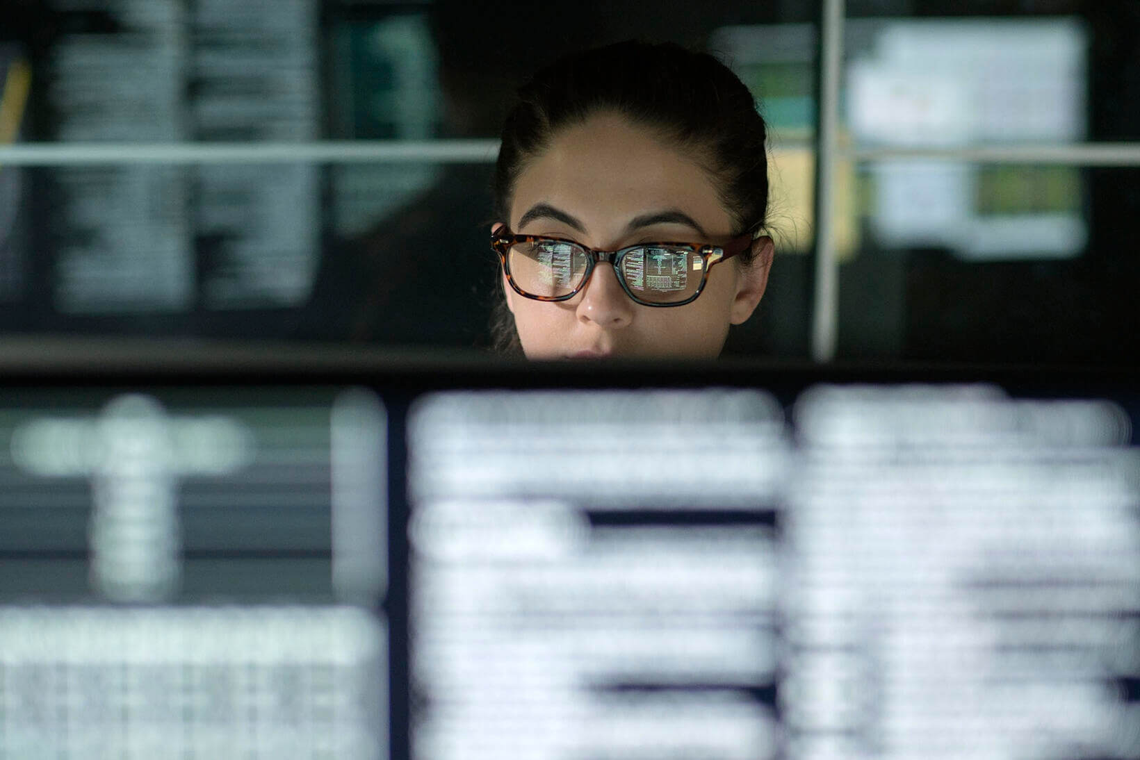  woman with glasses looking at the monitor while working in the office