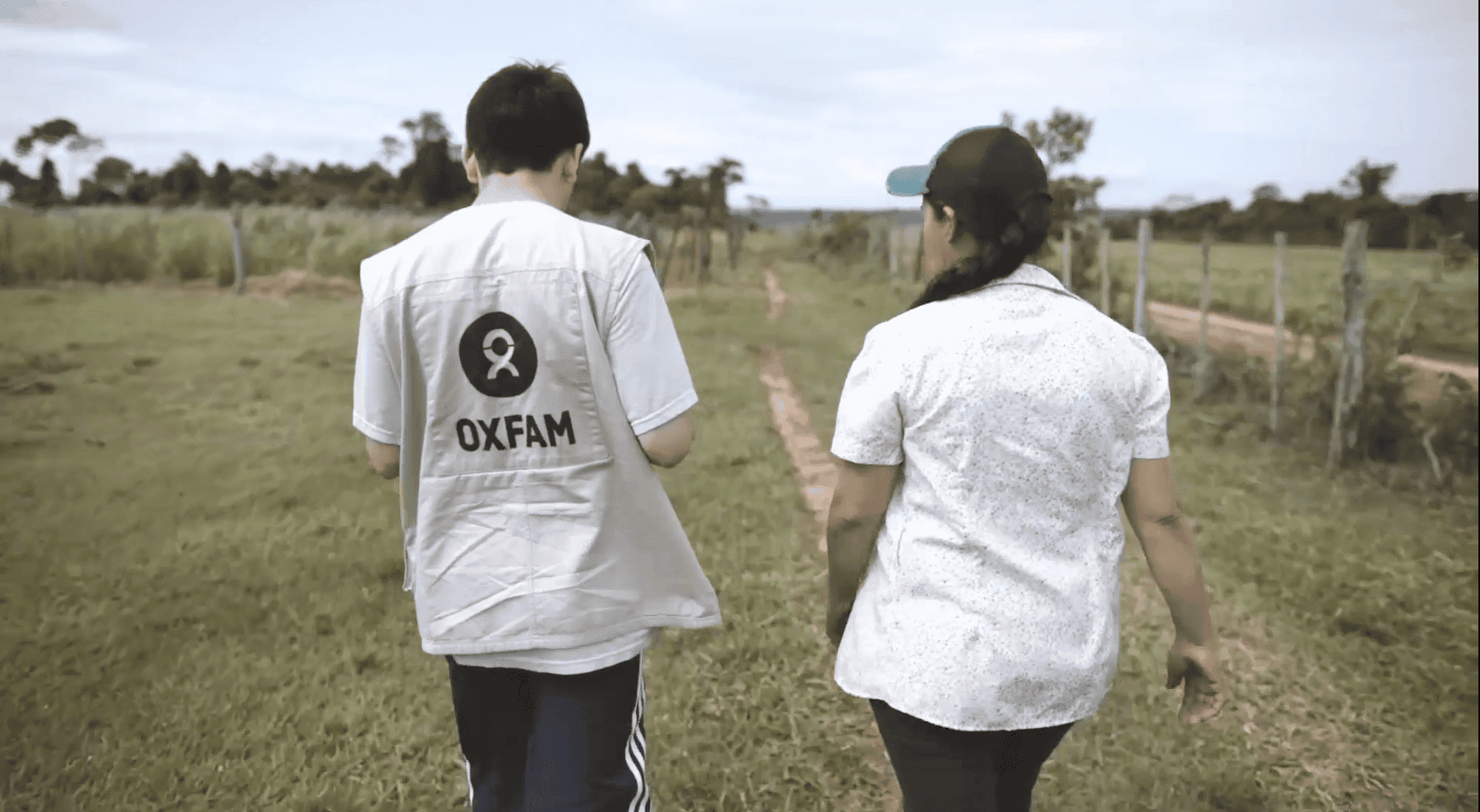 An Okfam volunteer talking with a person while walking.