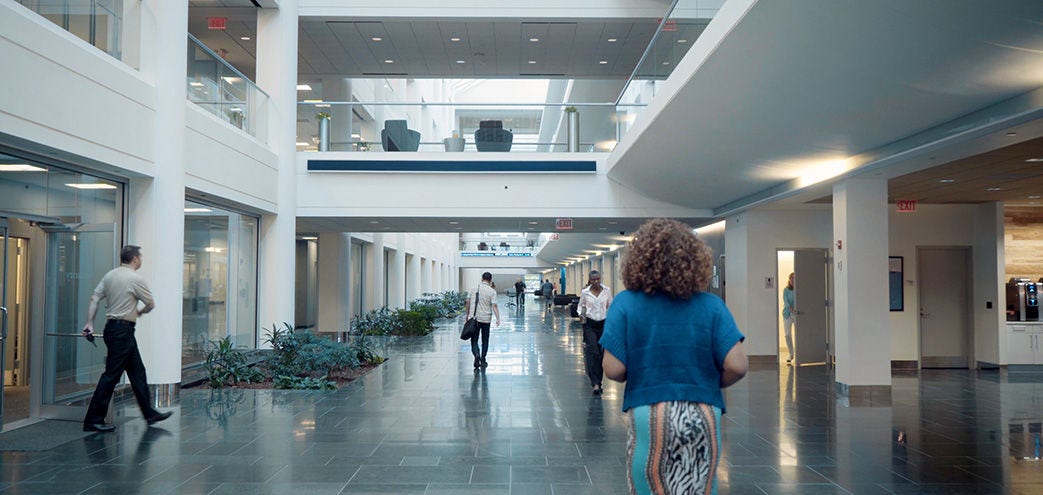 Image showing the inside of a corporate building showing people around.