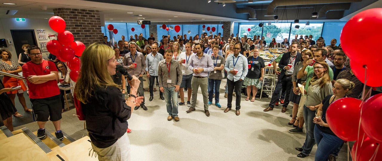  a speaker surrounded by listeners during a team-building event