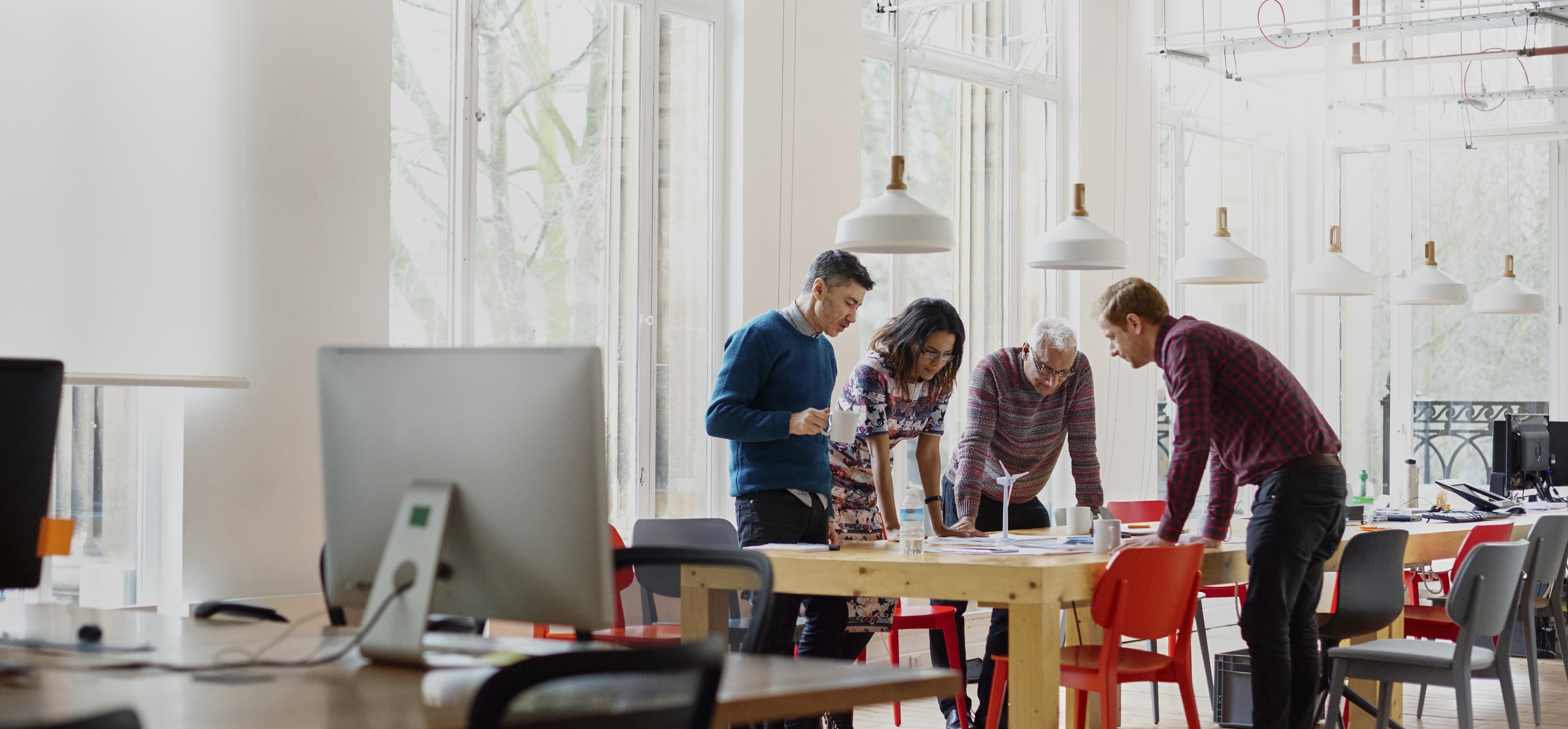 Teammates standing in an office planning a project at a desk