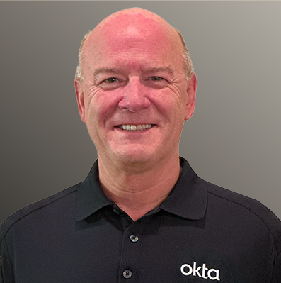 Peter Schuermann smiling in and Okta polo